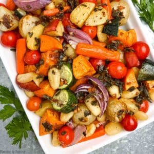 Overhead view of roasted gnocchi and fall vegetables on a large white platter.