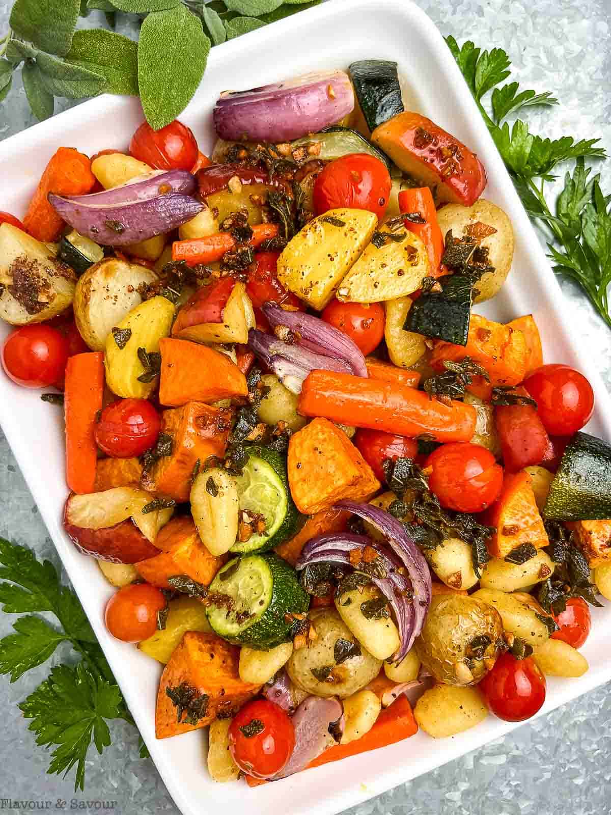 Overhead view of a platter of roasted vegetables with gluten-free gnocchi.