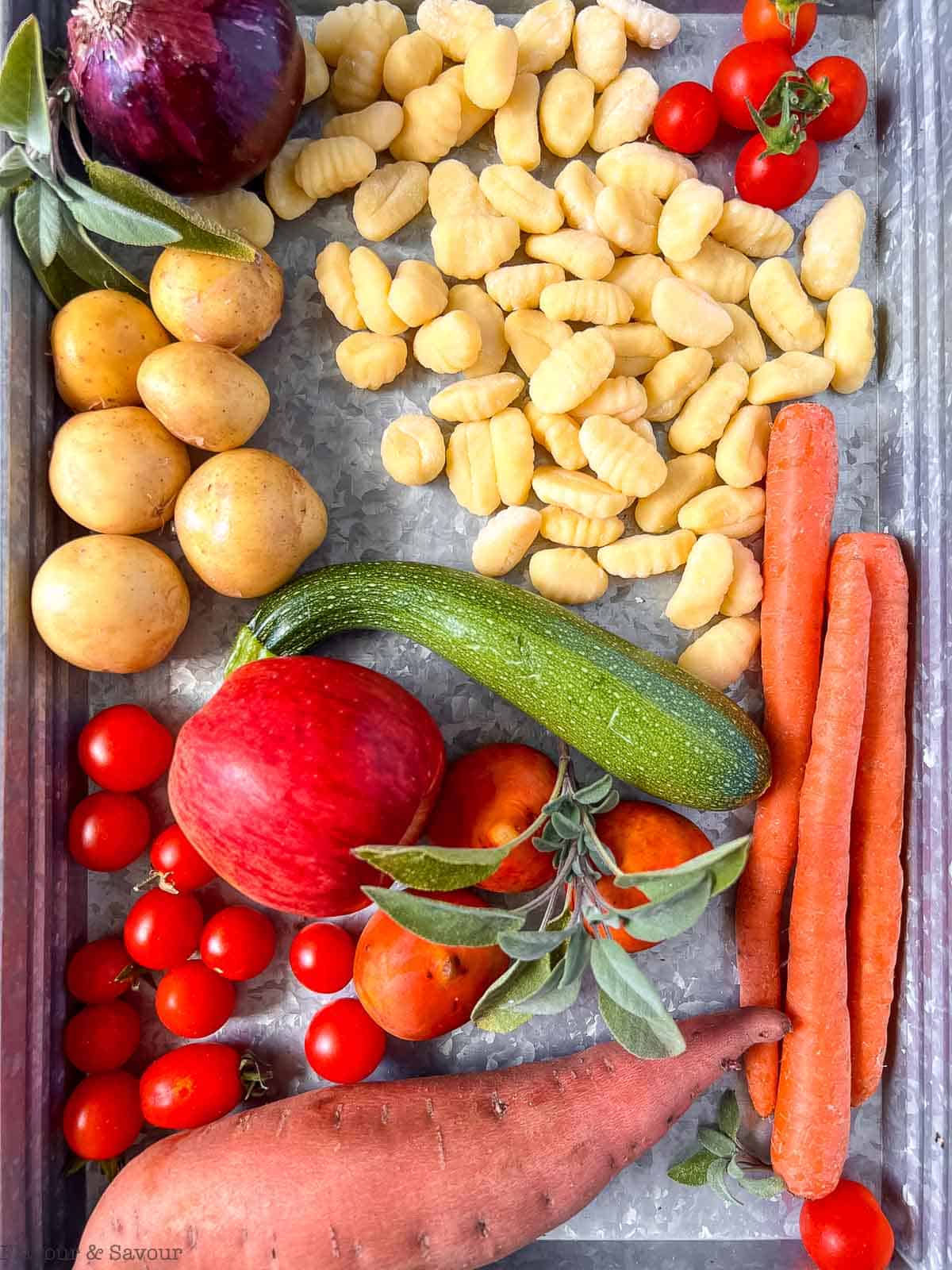 A tray holding the ingredients to make sheet pan gnocchi with fall vegetables.