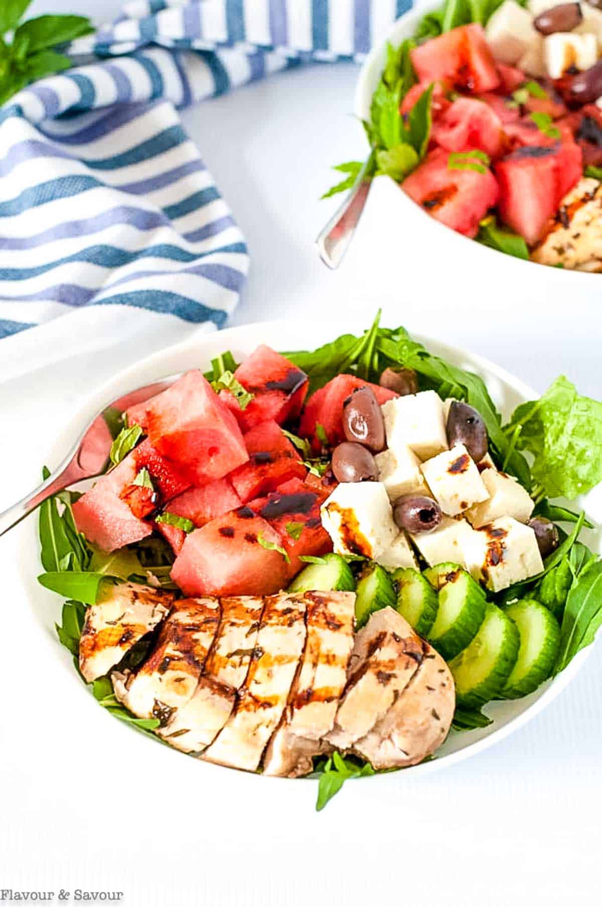 Overhead view of a bowl of Greek chicken salad with watermelon and feta.