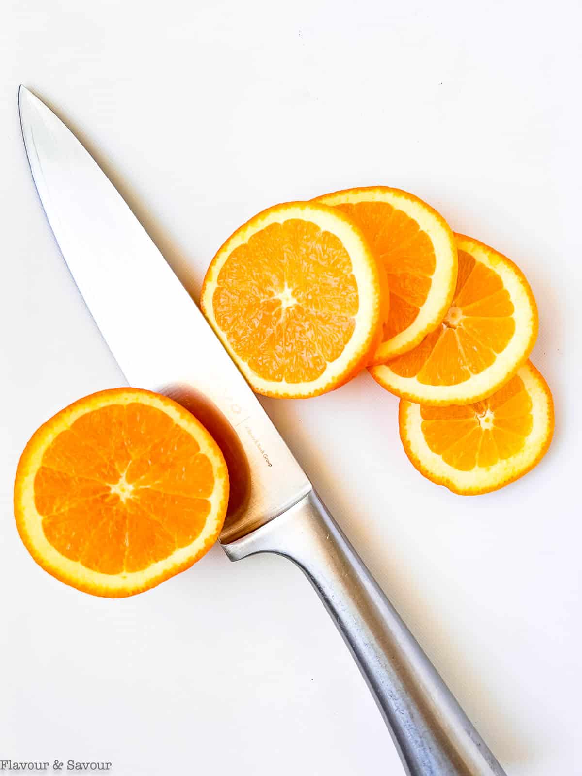Sliced oranges with a knife to make dried orange slices.