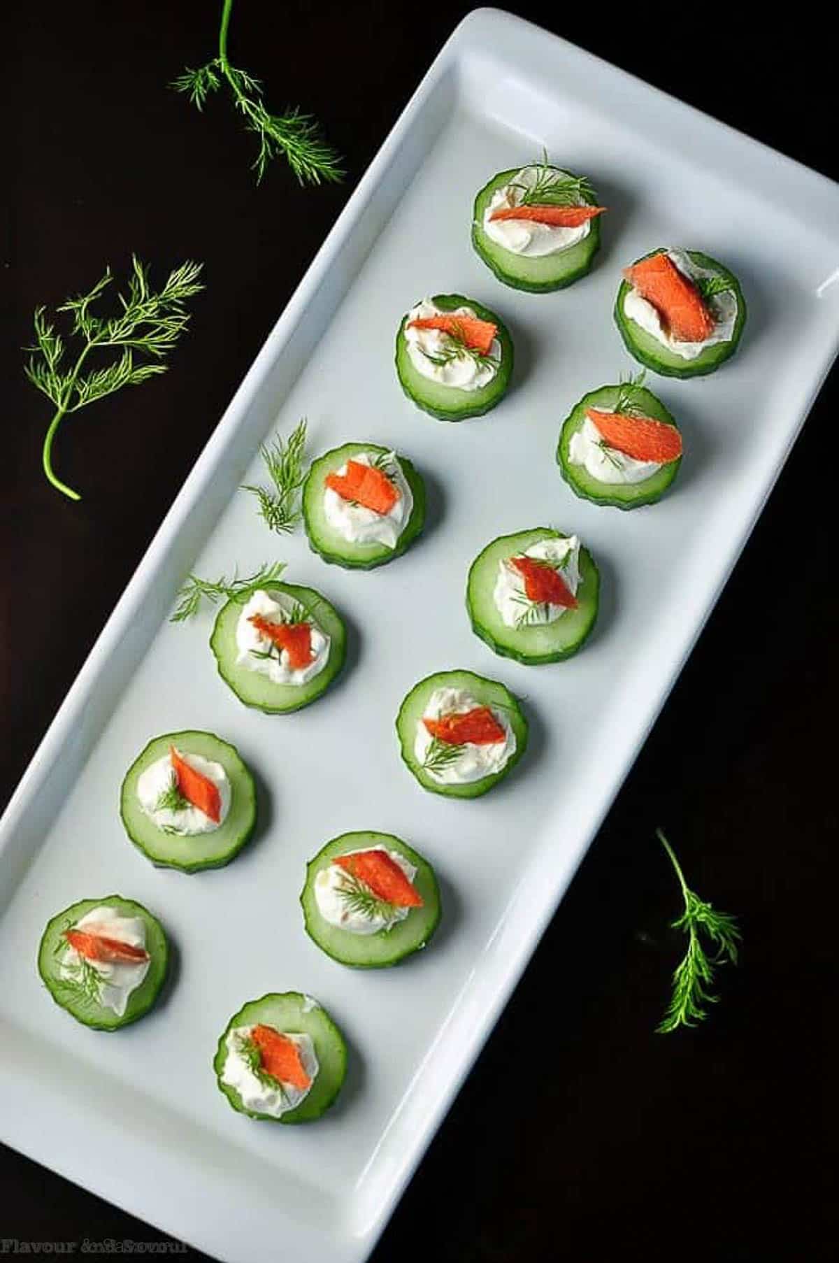Overhead view of Smoked Salmon Cucumber Bites on a white platter.