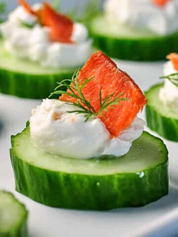 Close up view of a single smoked salmon cucumber bite with cream cheese and smoked salmon.