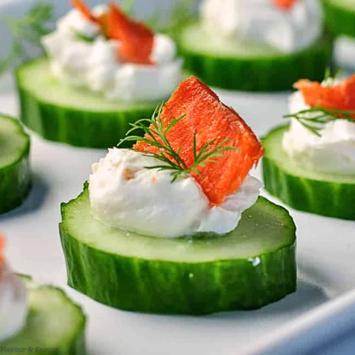 Close up view of a single cucumber bite with cream cheese and smoked salmon.