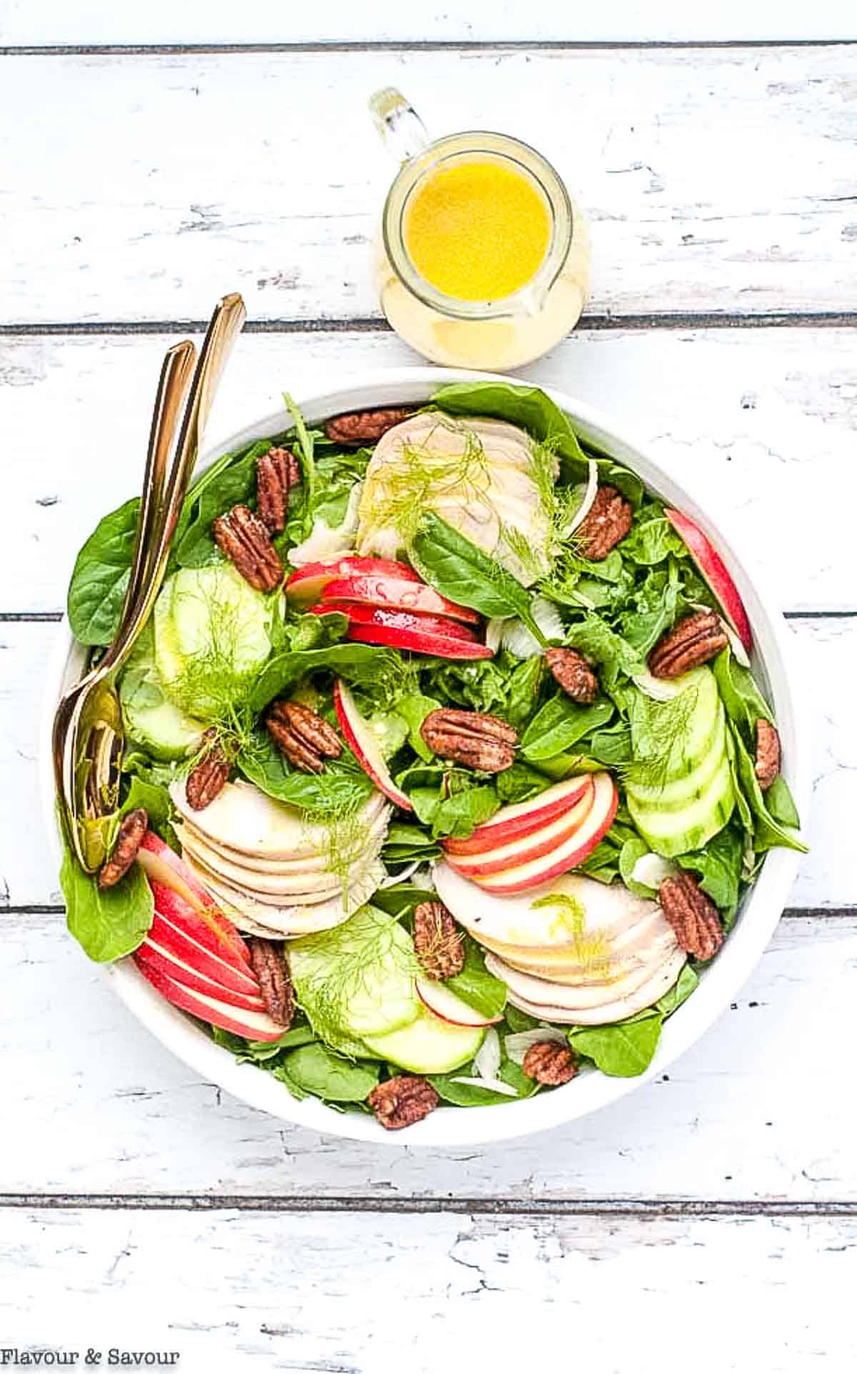 Fennel apple chicken salad with pumpkin spice pecans in a shallow round bowl.