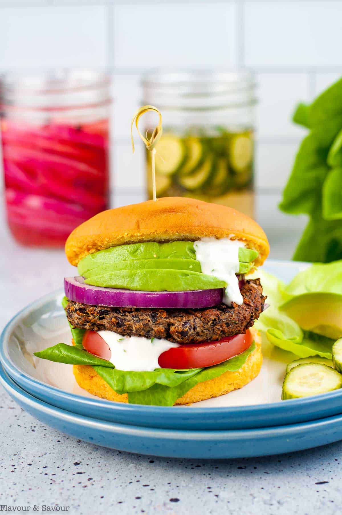 A Mushroom Black Bean Burger with lettuce, tomato, red onion, avocado and lemon aioli.