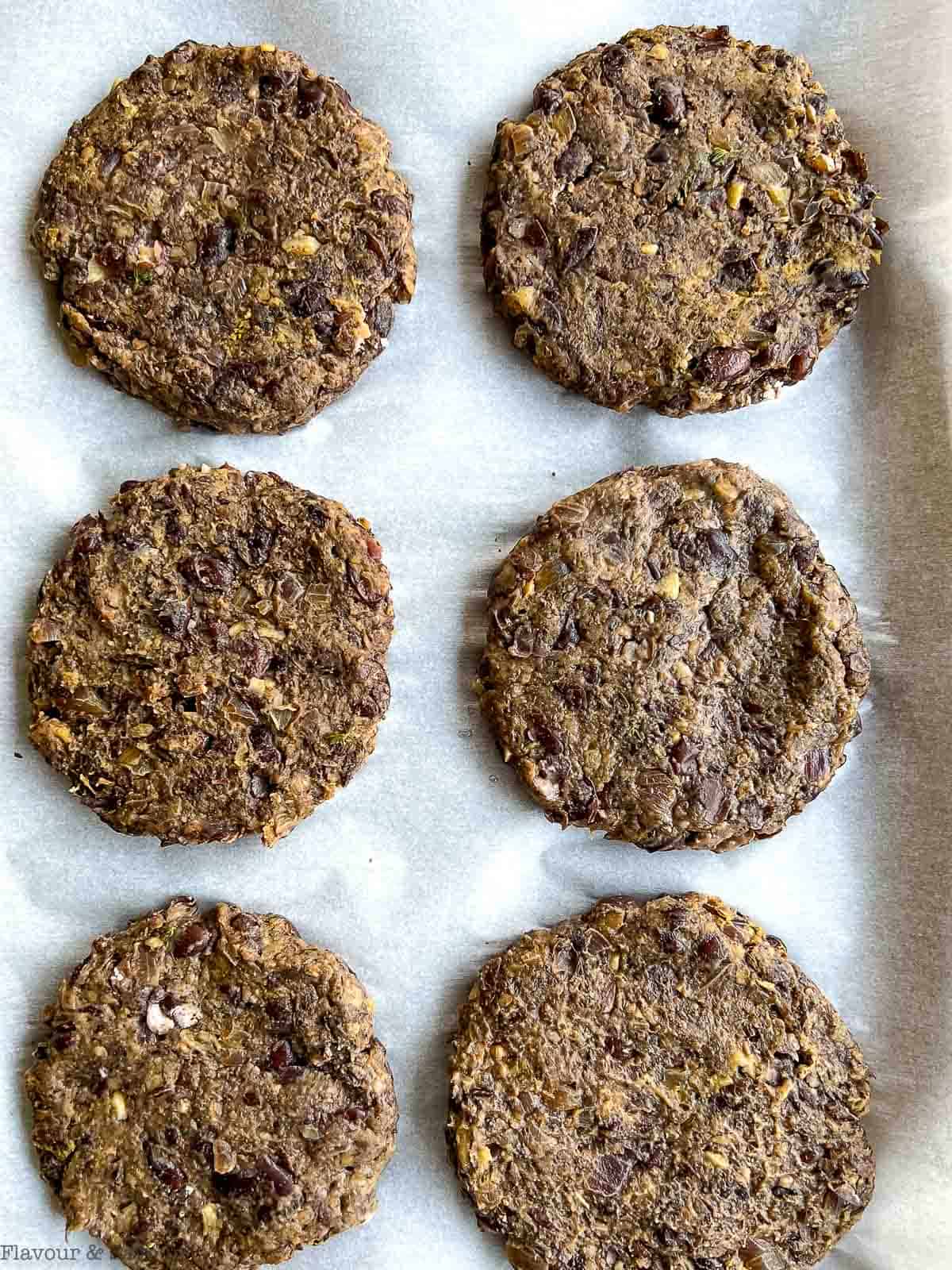 6 mushroom burgers on a baking sheet, ready to cook or freeze.