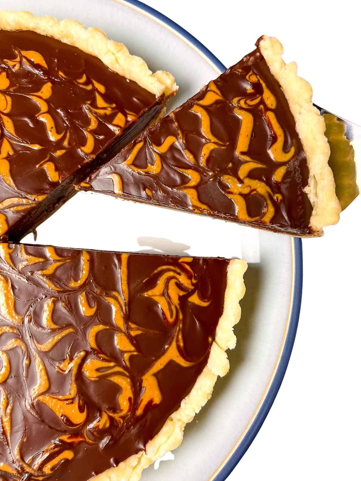 A slice of vegan chocolate-coconut cream tart with peanut butter swirl.