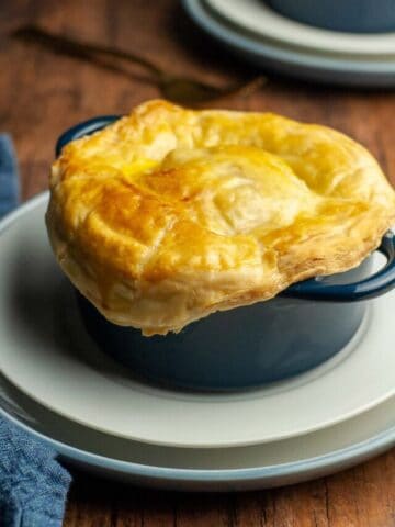 An individual seafood pot pie with puff pastry crust in a cocotte..