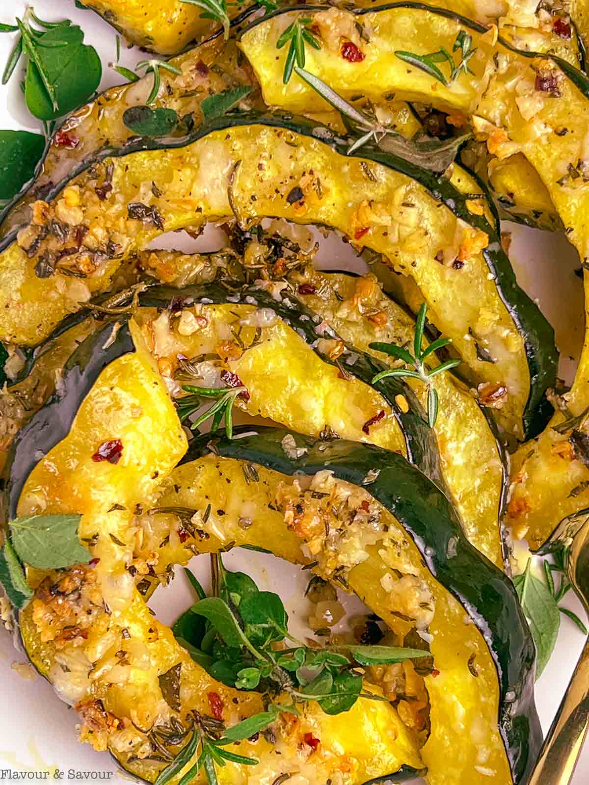 Close up view of garlic parmesan crusted roasted acorn squash slices.