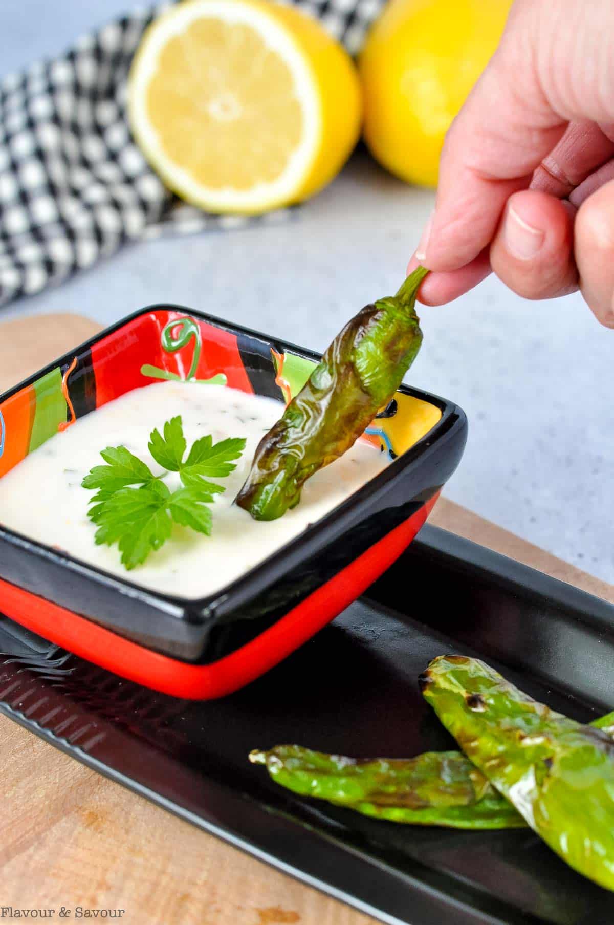 Dipping a padron (shishito) pepper into lemon aioli.