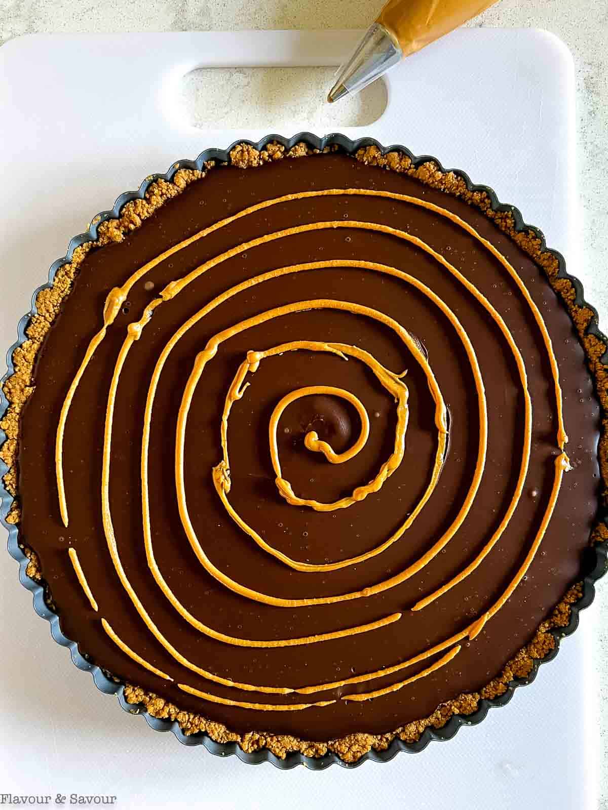 Peanut butter piped in circles on chocolate ganache.