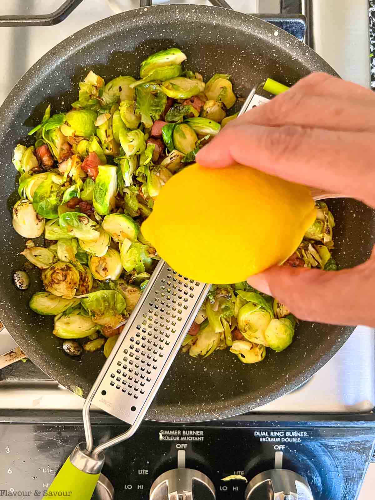 Adding lemon zest to Brussels sprouts and pancetta.