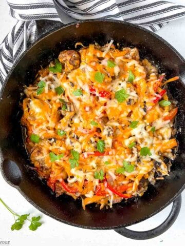 Overhead view of a cast iron skillet with baked chicken fajita casserole.