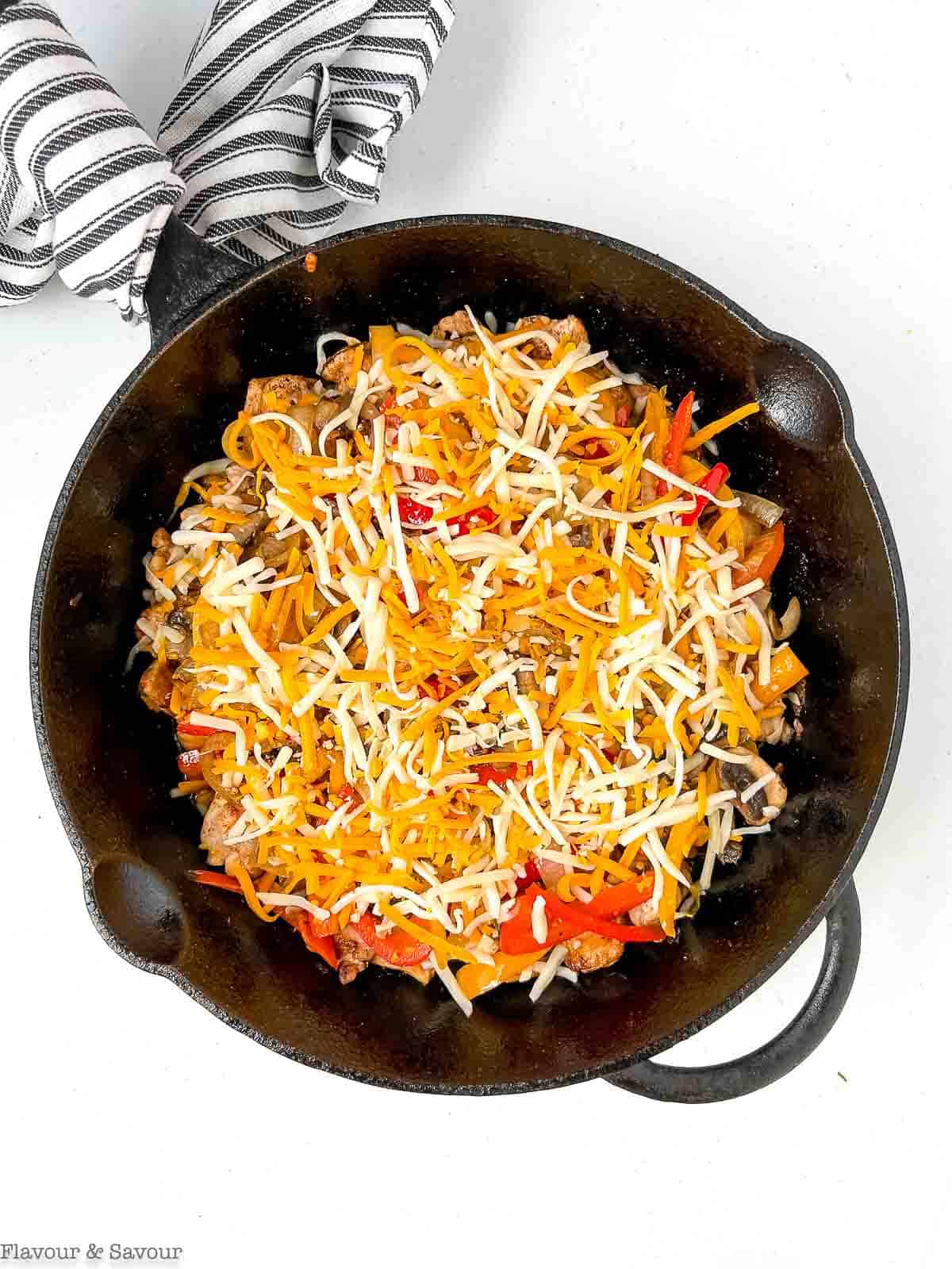 Grated cheese on top of chicken fajita casserole.