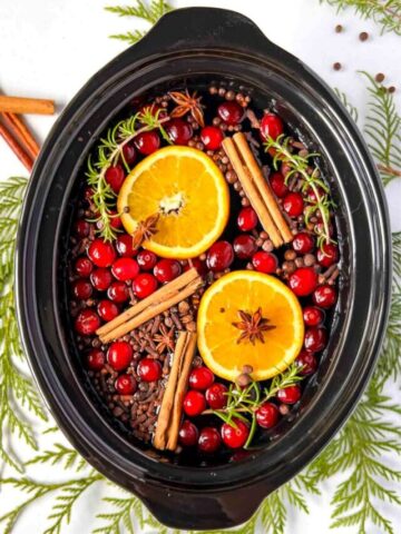 Overhead view of a slow cooker bowl with simmering holiday potpourri.