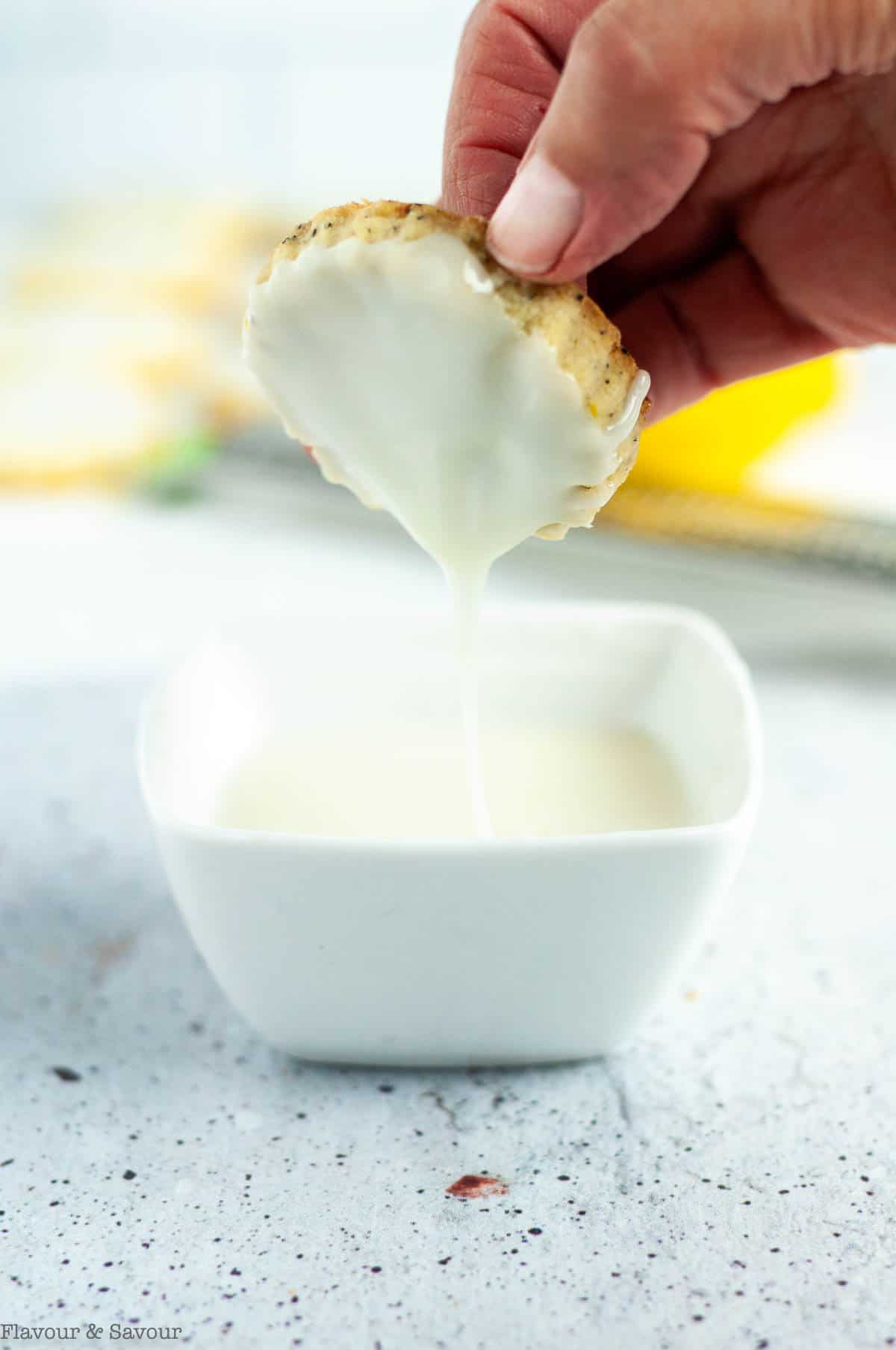 Dipping an Earl Gray cookie into lemon glaze.