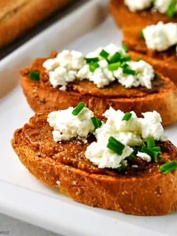 Three crostini appetizers with orange-fig compote and goat cheese.