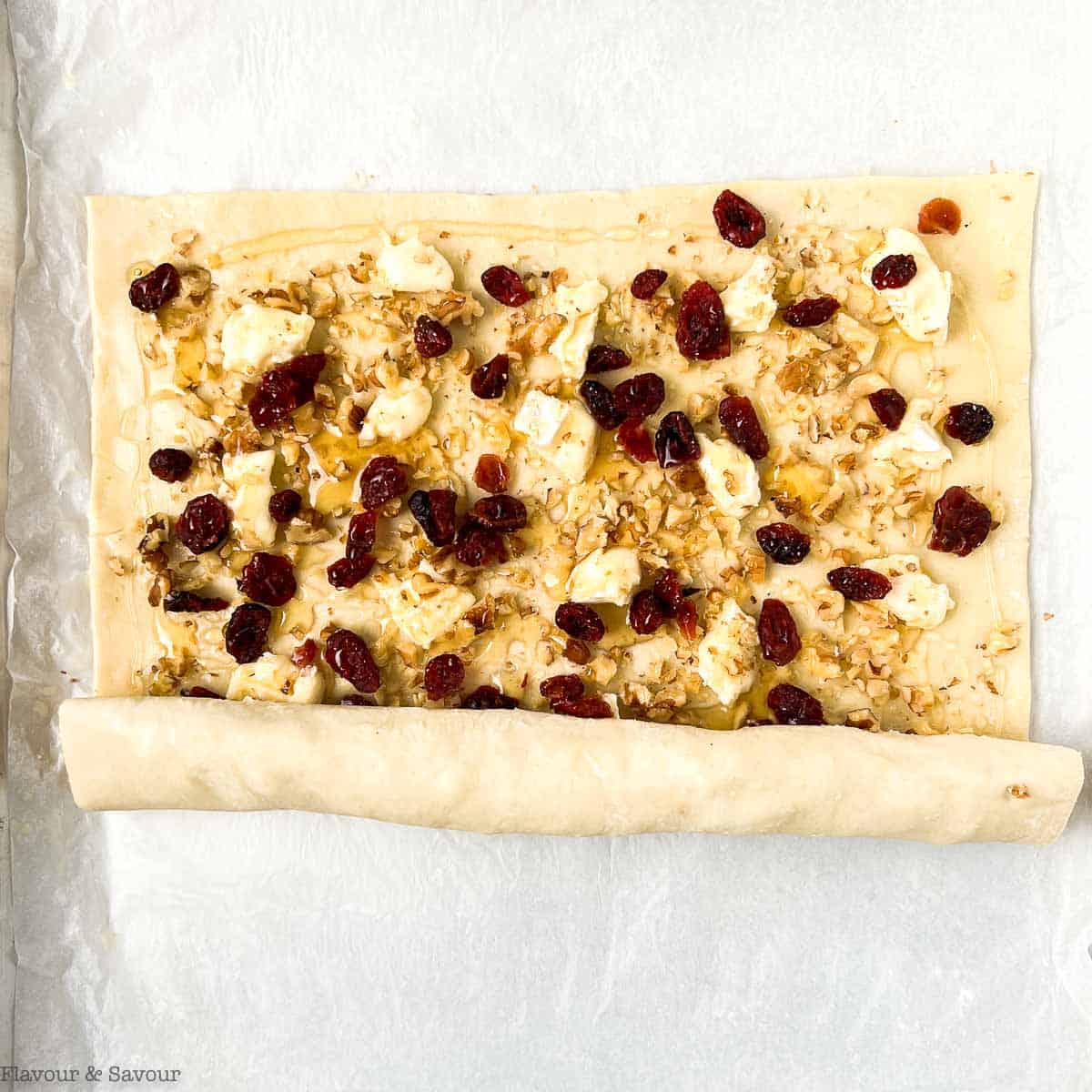 Rolling puff pastry filled with cranberries, Brie and walnuts.