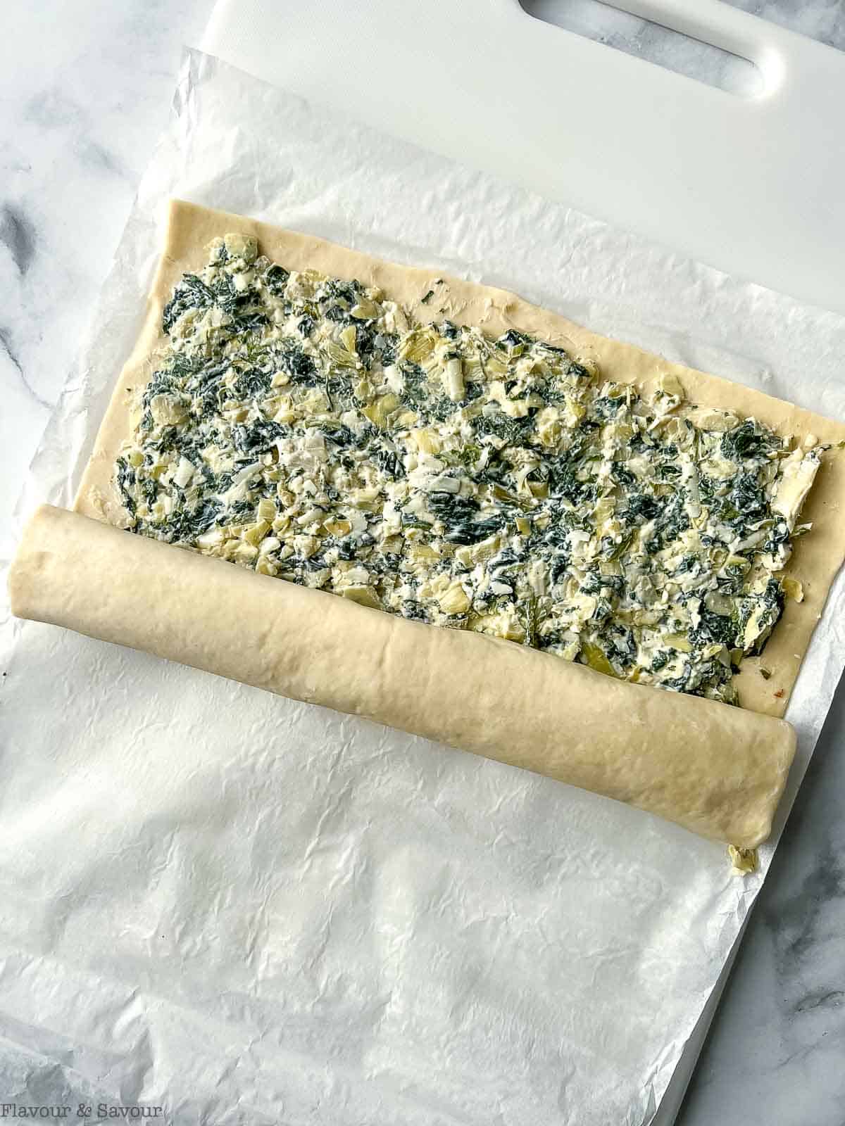 Rolling puff pastry dough to make pinwheels.