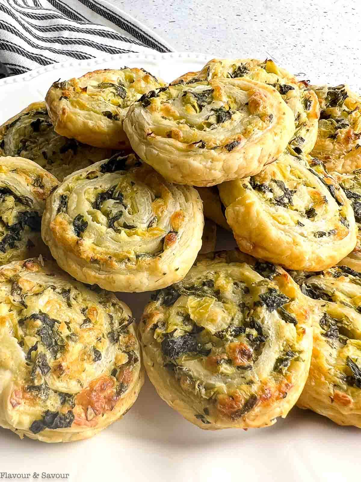 Puff pastry spinach artichoke pinwheels in a stack.