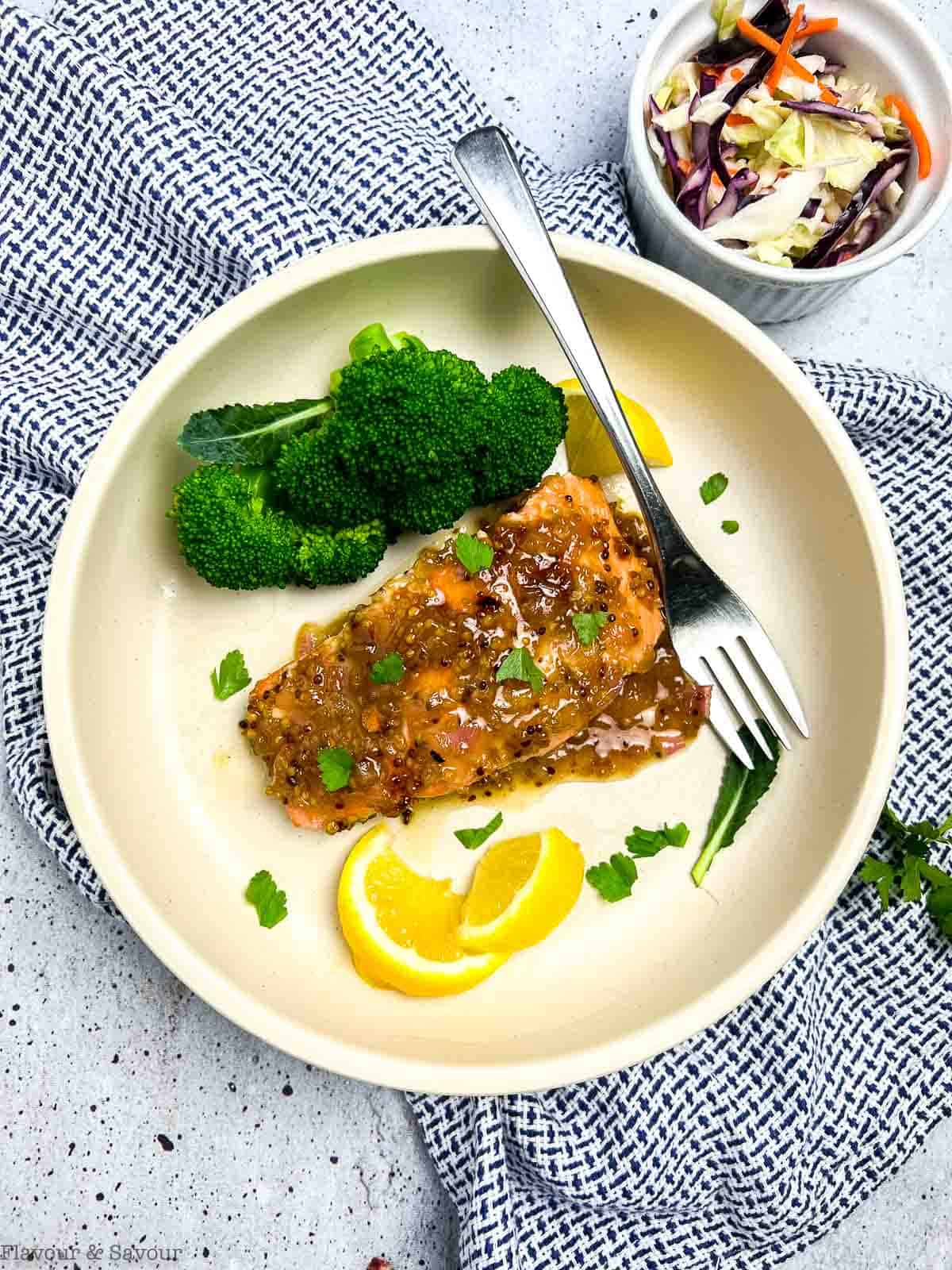 Overhead view of a salmon fillet with honey-Dijon sauce and broccoli.