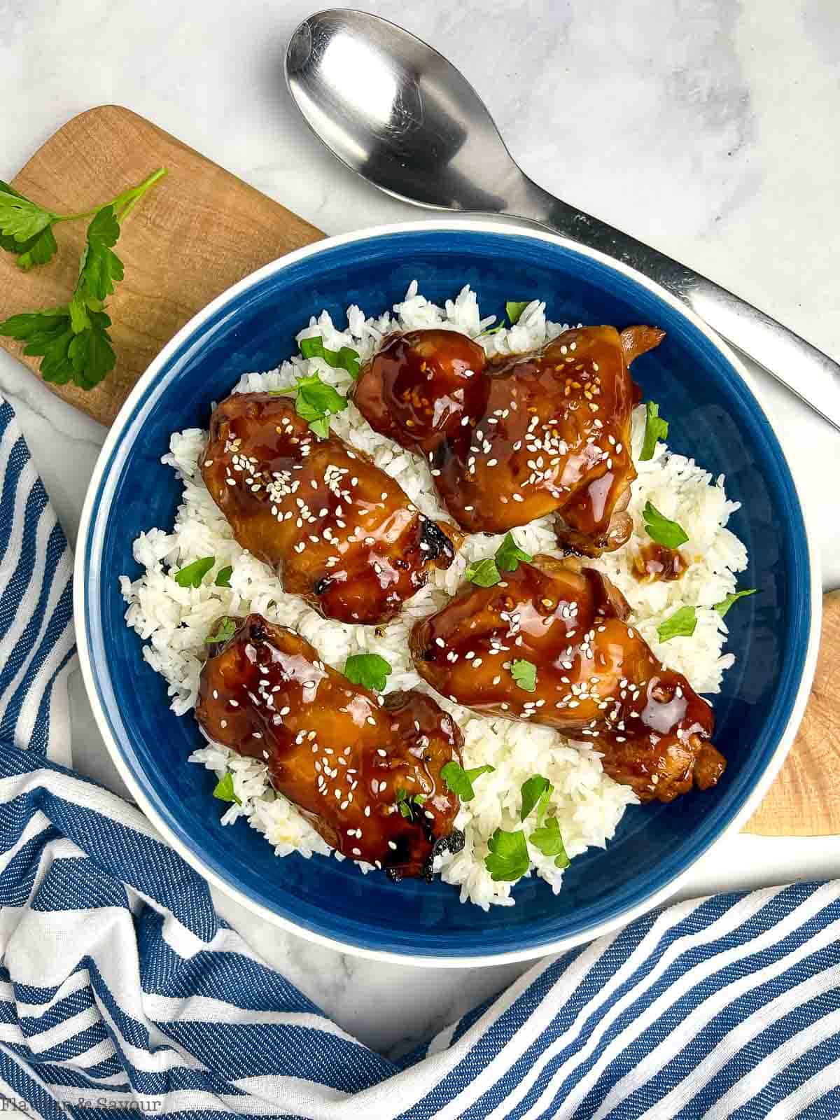 Teriyaki sauce on chicken thighs on a bed of rice.