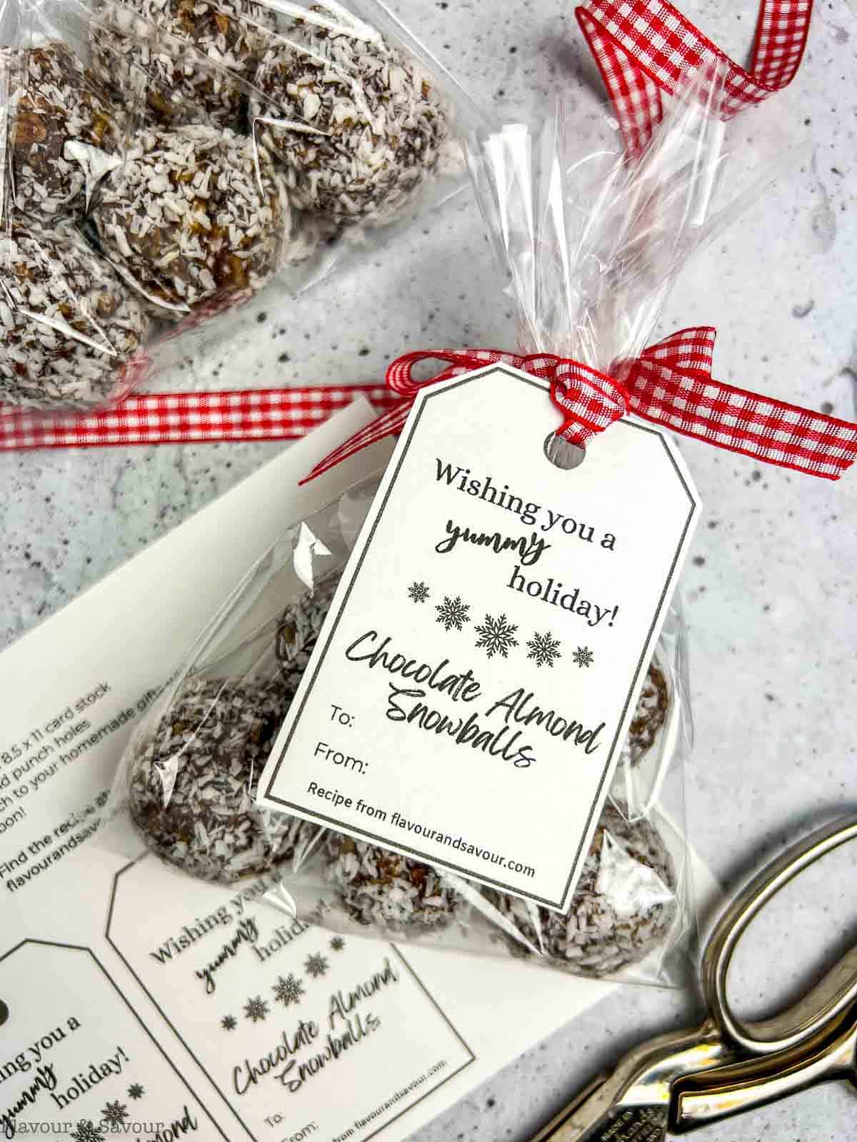 Chocolate almond snowballs in a cellophane bag with a gift tag.