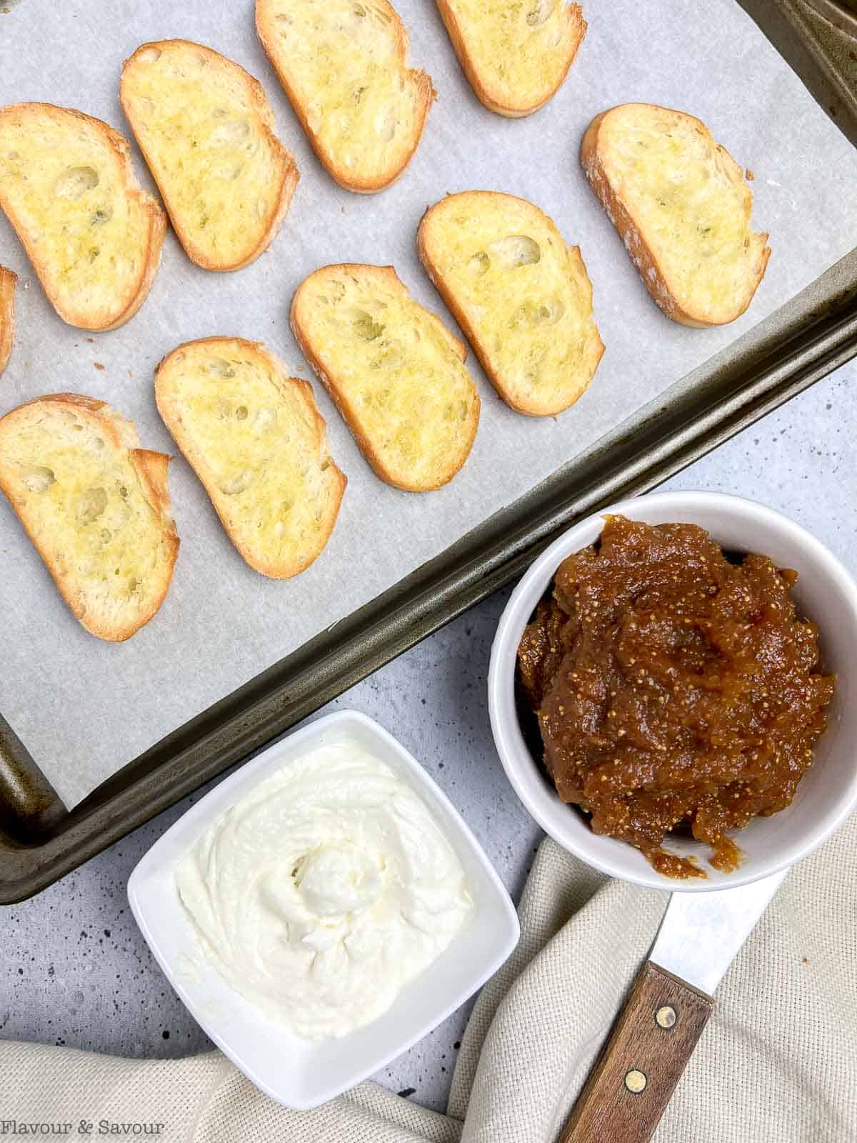 Crostini with a small bowl of fig compote and one of whipped goat cheese.