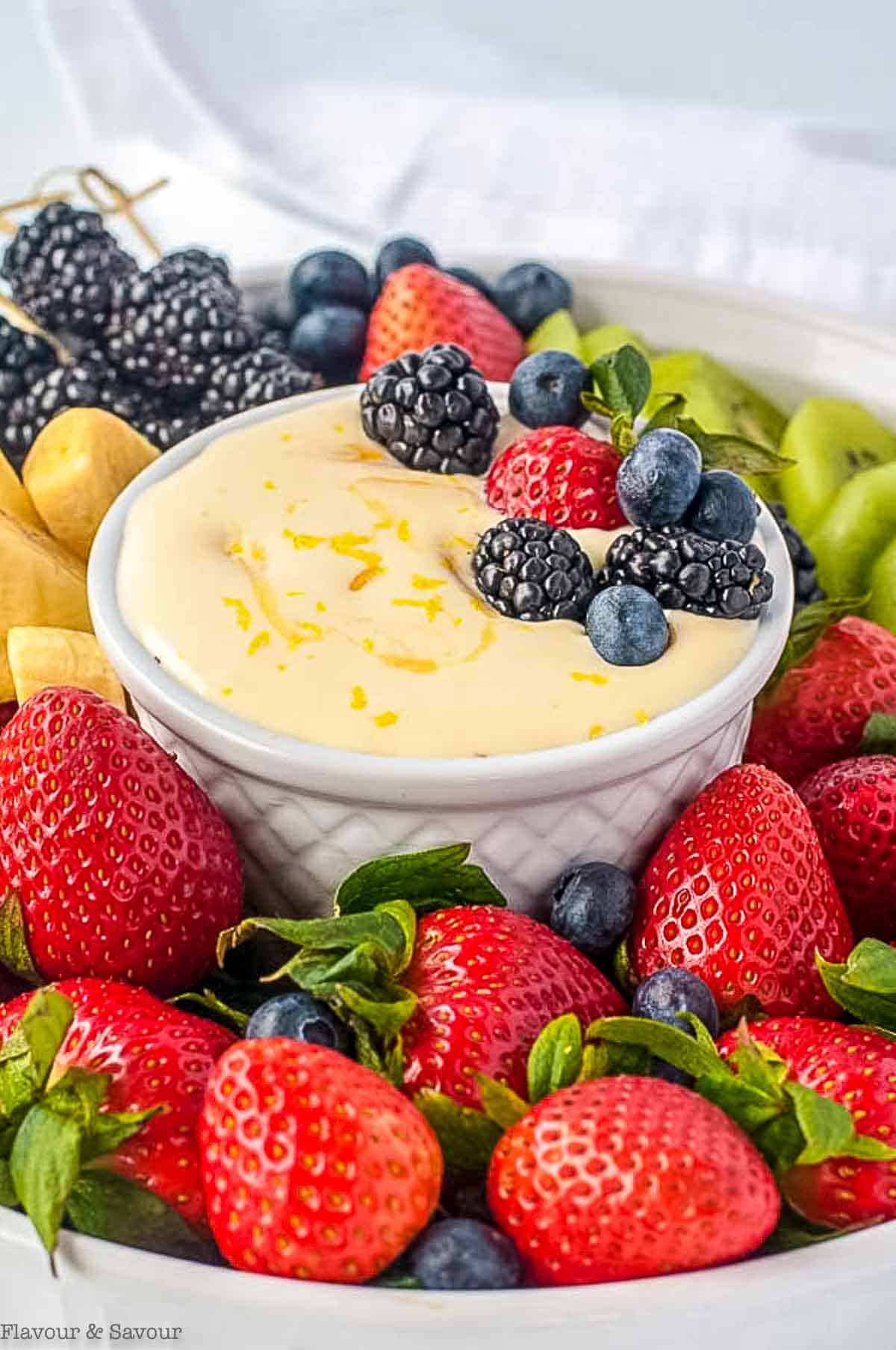 Close up view of a fruit platter with a bowl of lemon curd dip.