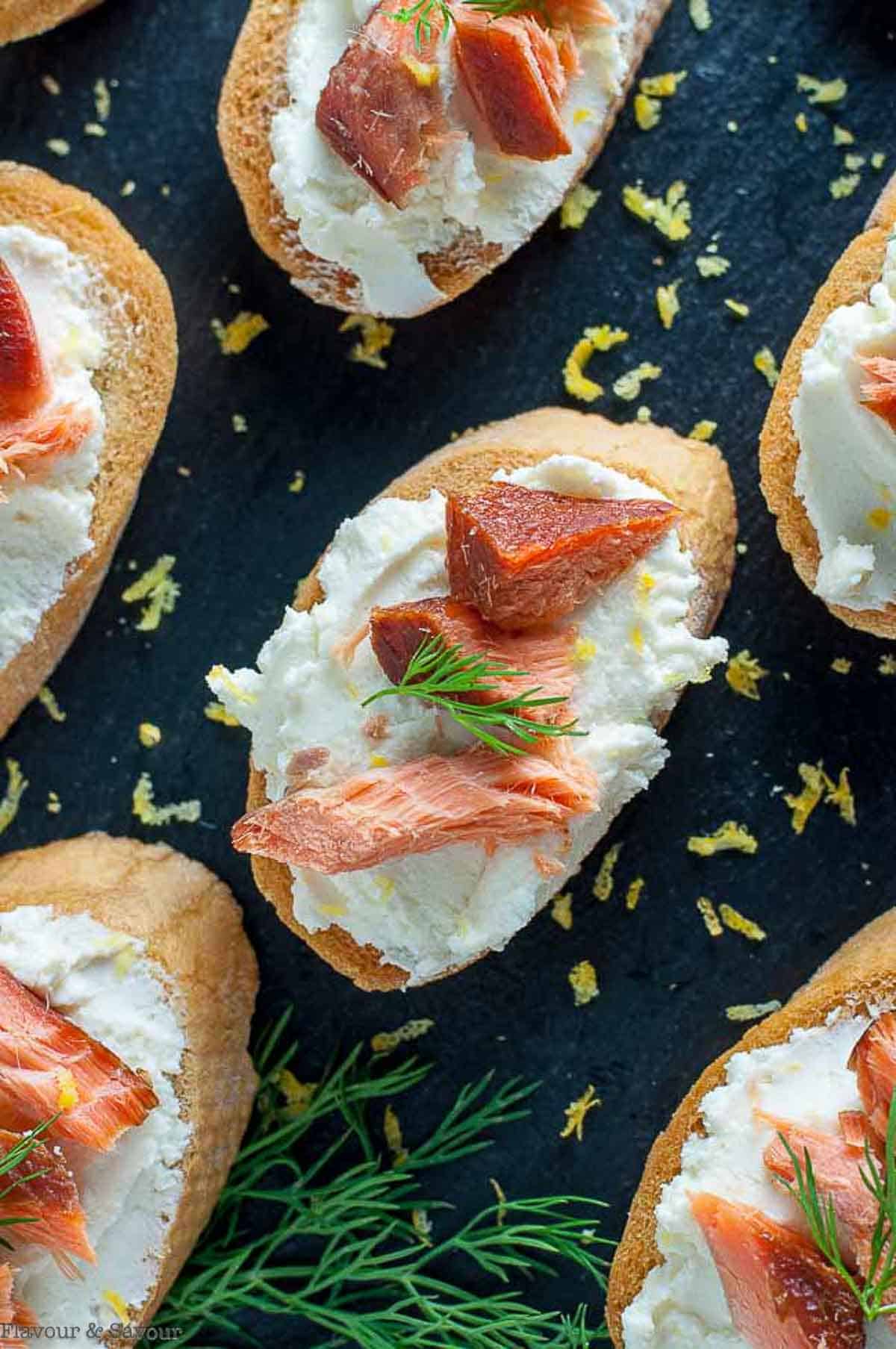Smoked salmon crostini on gluten-free baguette slices sprinkled with lemon zest.