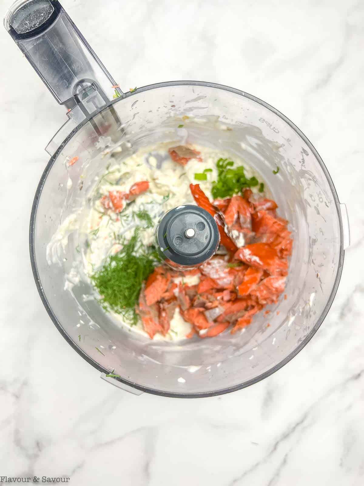 Adding smoked salmon, dill and green onions to dip in food processor.