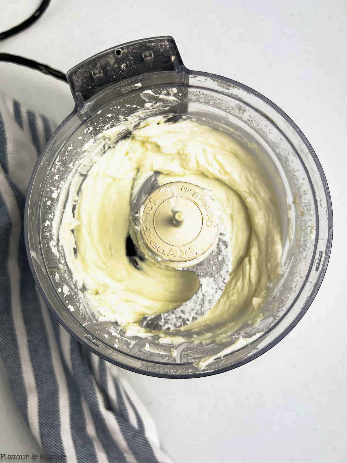 Whipped goat cheese mixture in a mini food processor bowl.