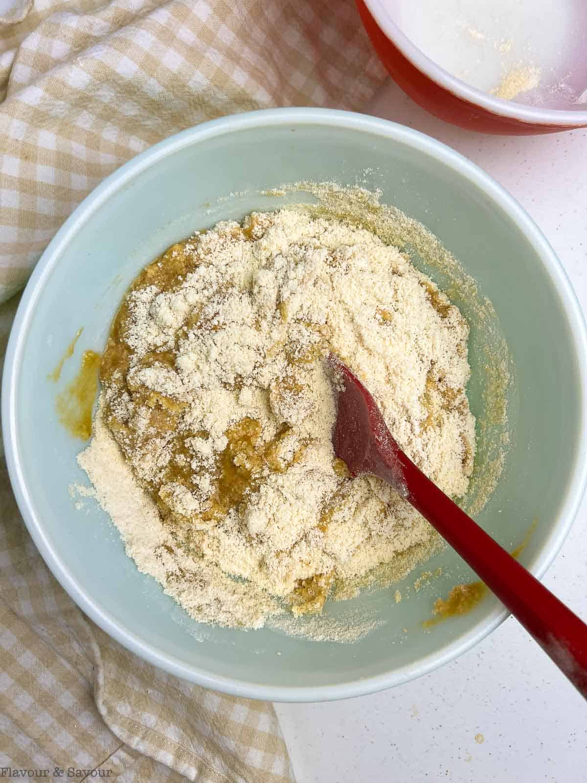 Combining wet and dry ingredients to make gluten-free banana muffins.