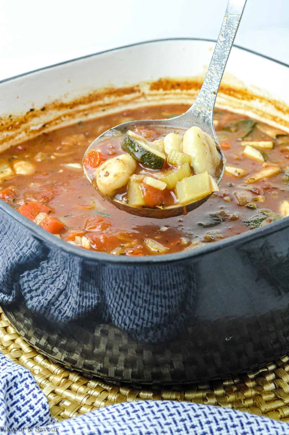 A ladleful of vegetable soup with gluten-free gnocchi.