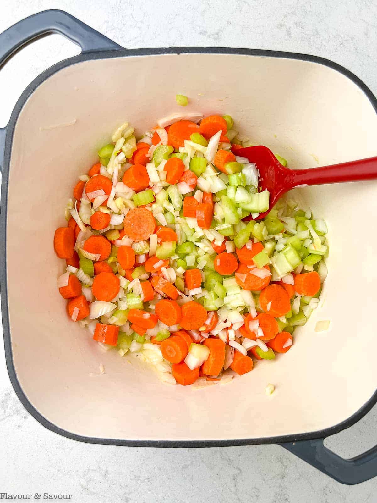 Sautéed vegetables in a soup pot.