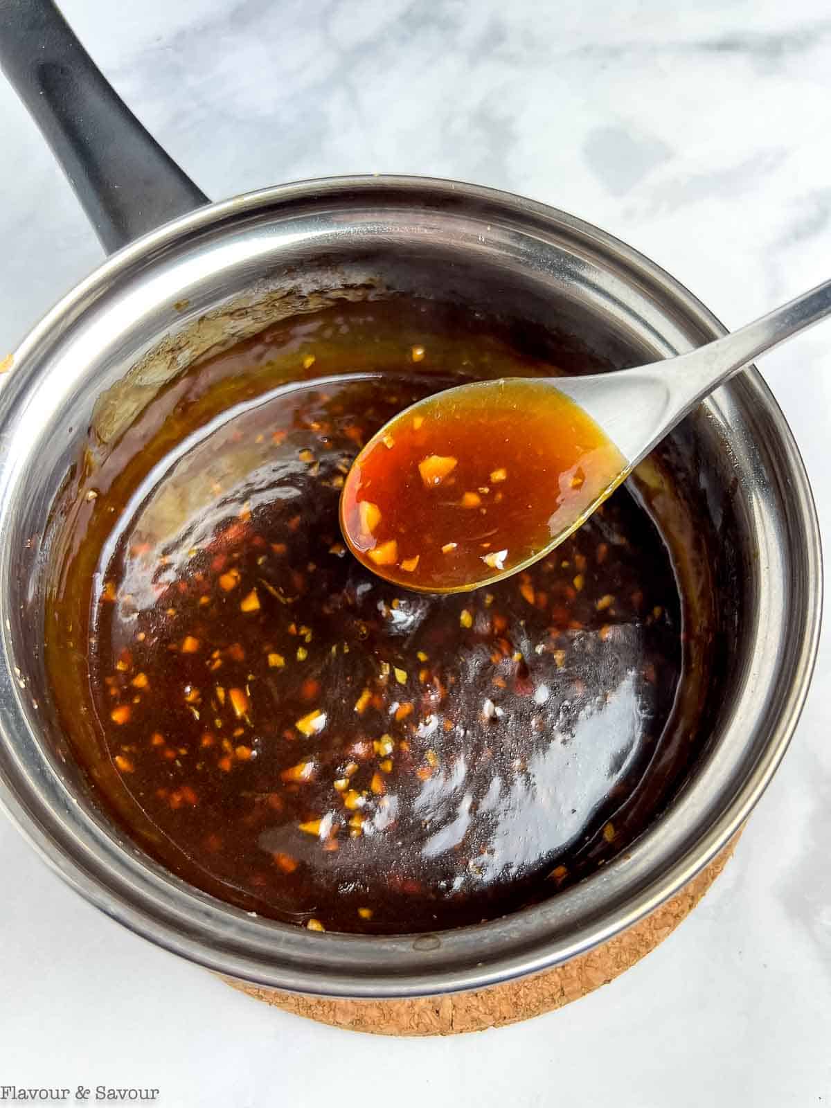 Stirring teriyaki glaze in a saucepan.