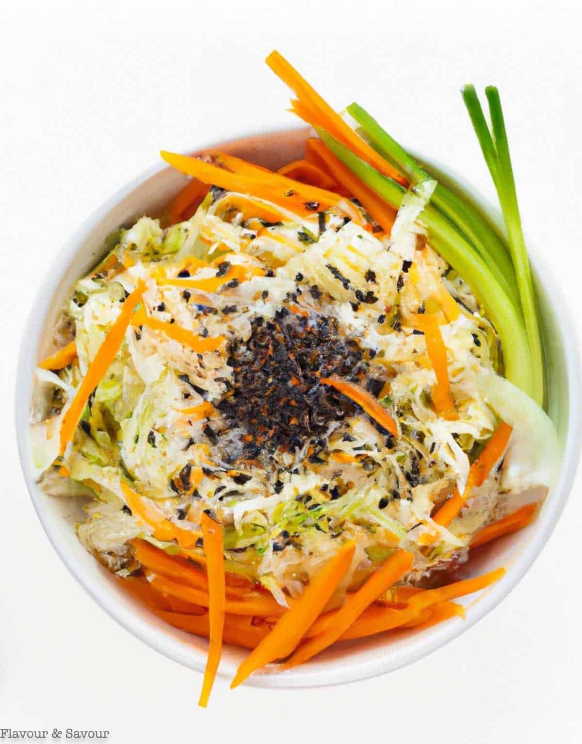 Overhead view of a shallow white bowl with Thai slaw.