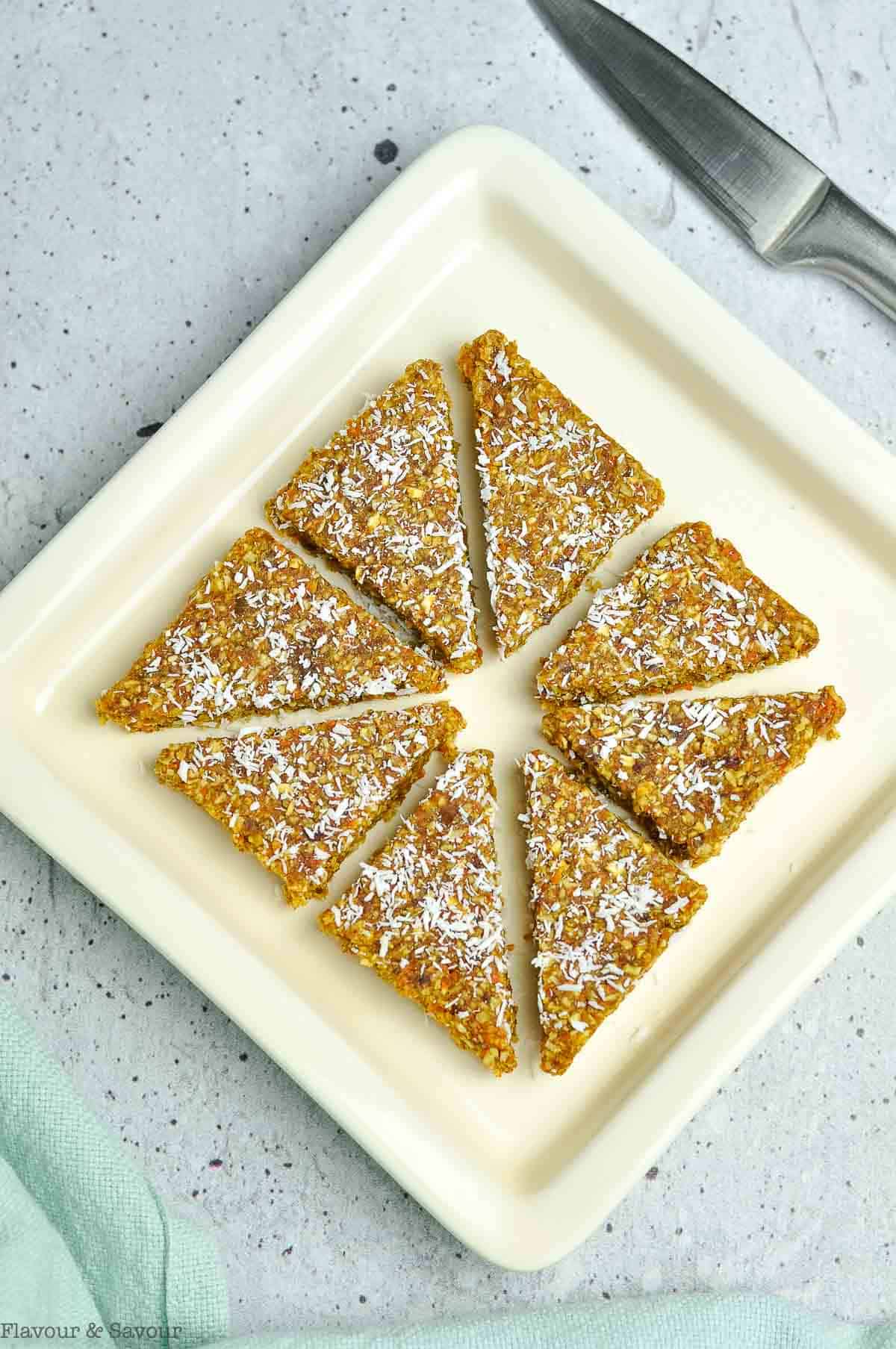 A square plate with carrot cake bites mixture sliced into triangles.
