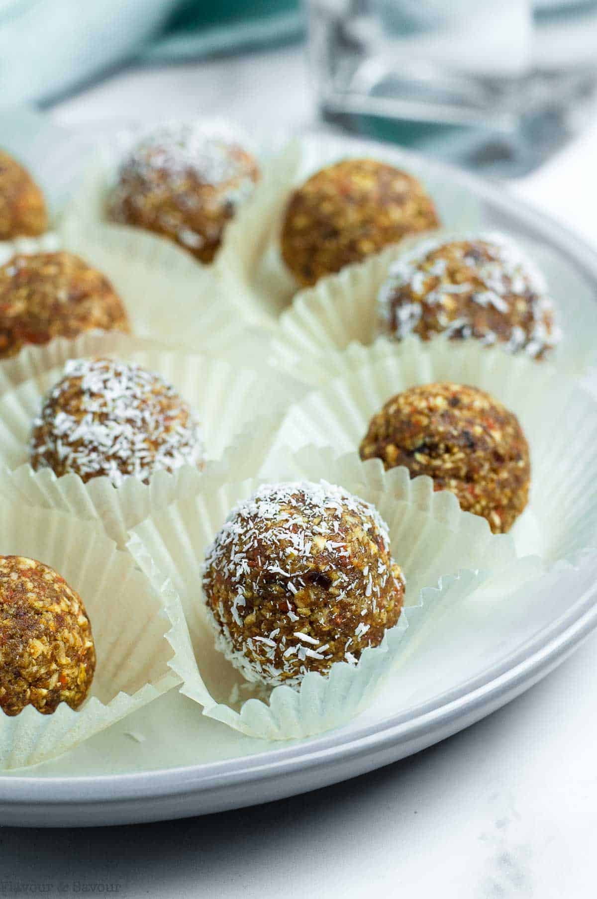 Carrot cake energy bites in small cake cases on a plate.