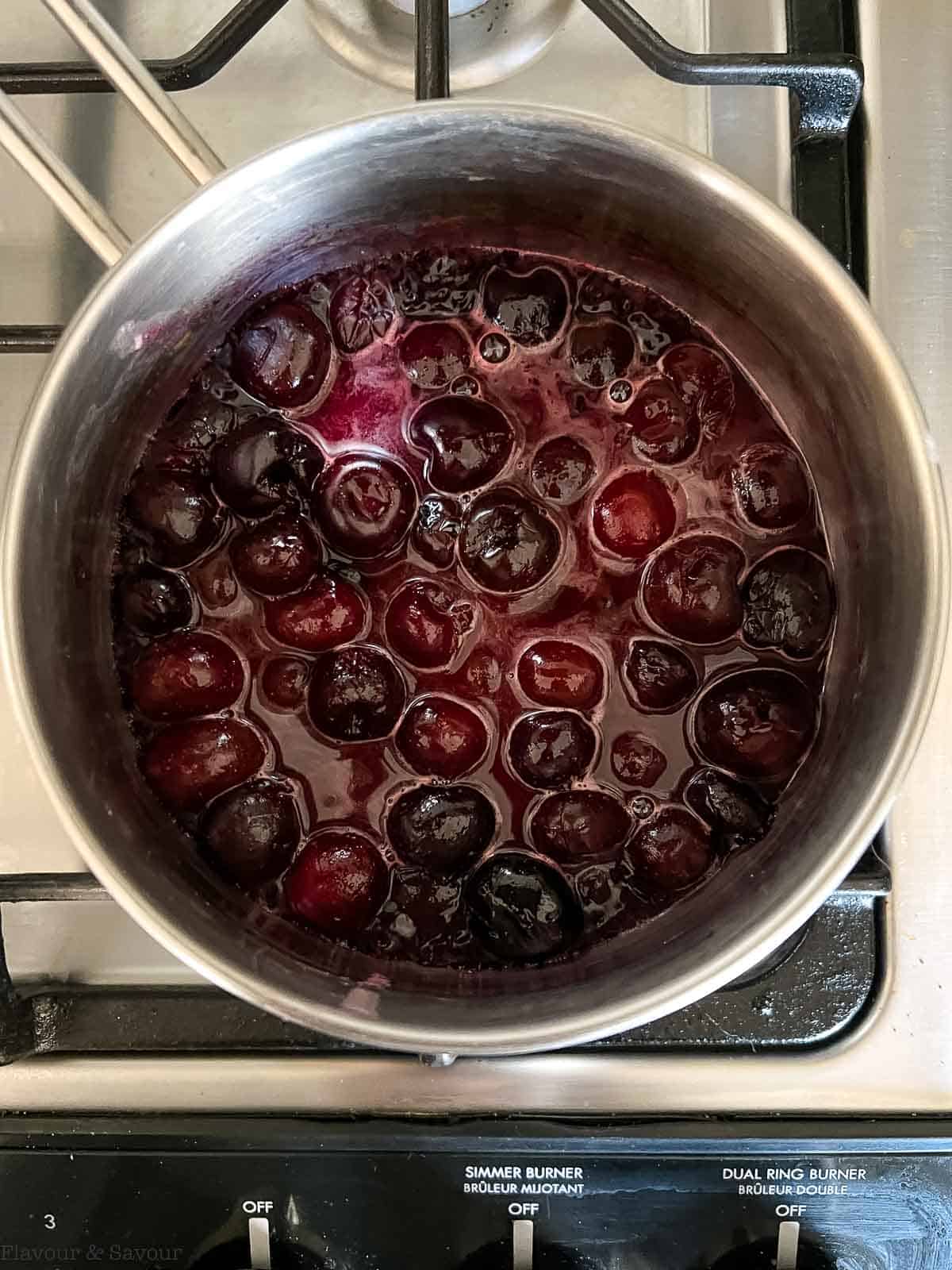 Cherry pie filling in a saucepan on the stove.