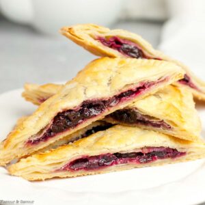 Gluten-free puff pastry cherry hand pies stacked.