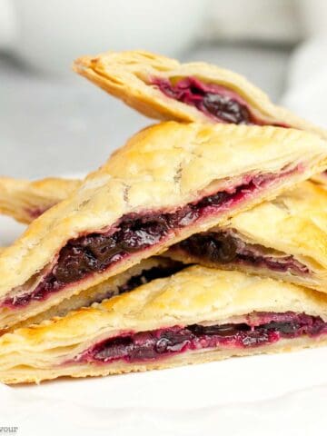 Gluten-free puff pastry cherry hand pies stacked.