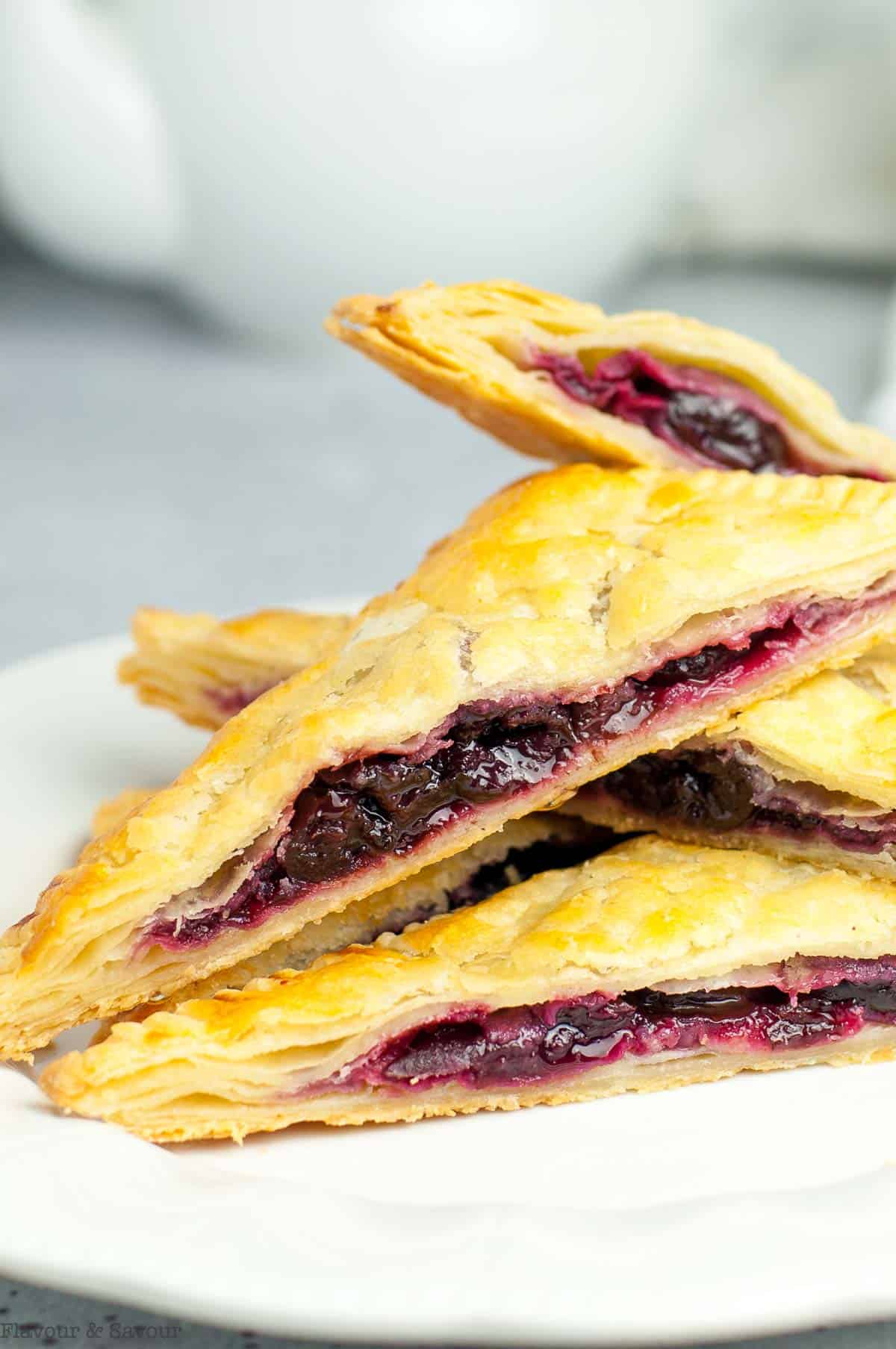 A stack of cherry hand pies, sliced to show the cherry filling.