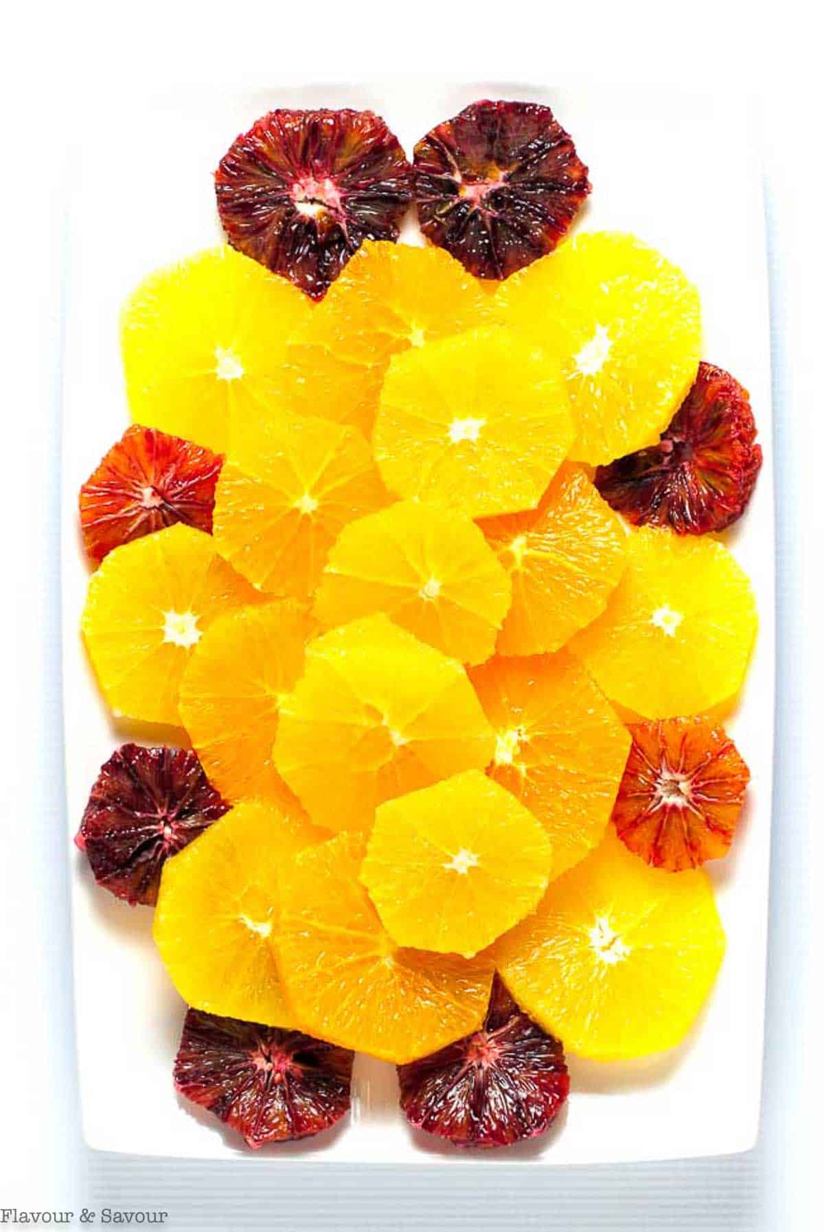 Step 1 to make citrus salad. Slice oranges into wheels and arrange on a platter.