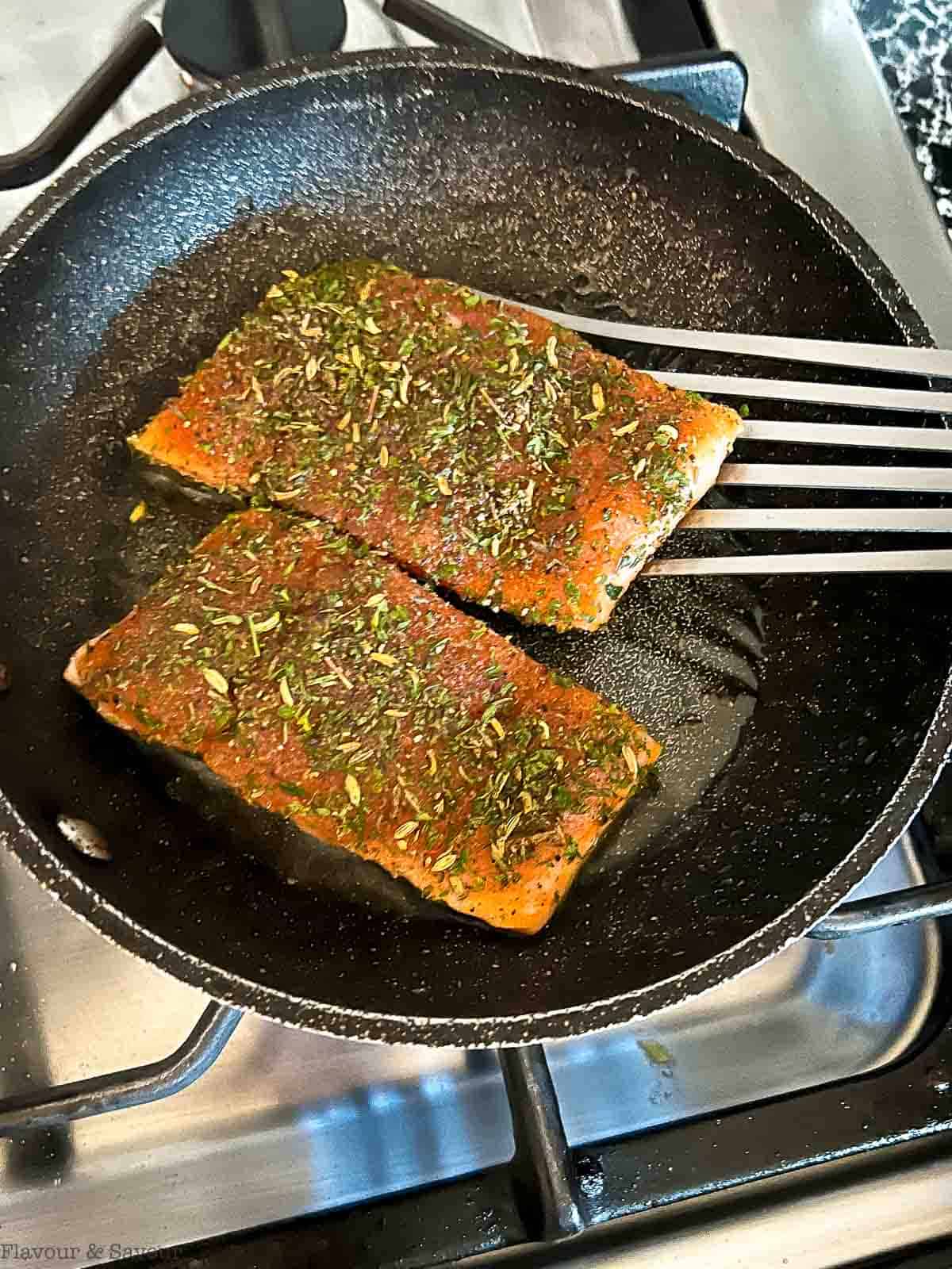 Flipping jerk salmon fillets with a fish turner.