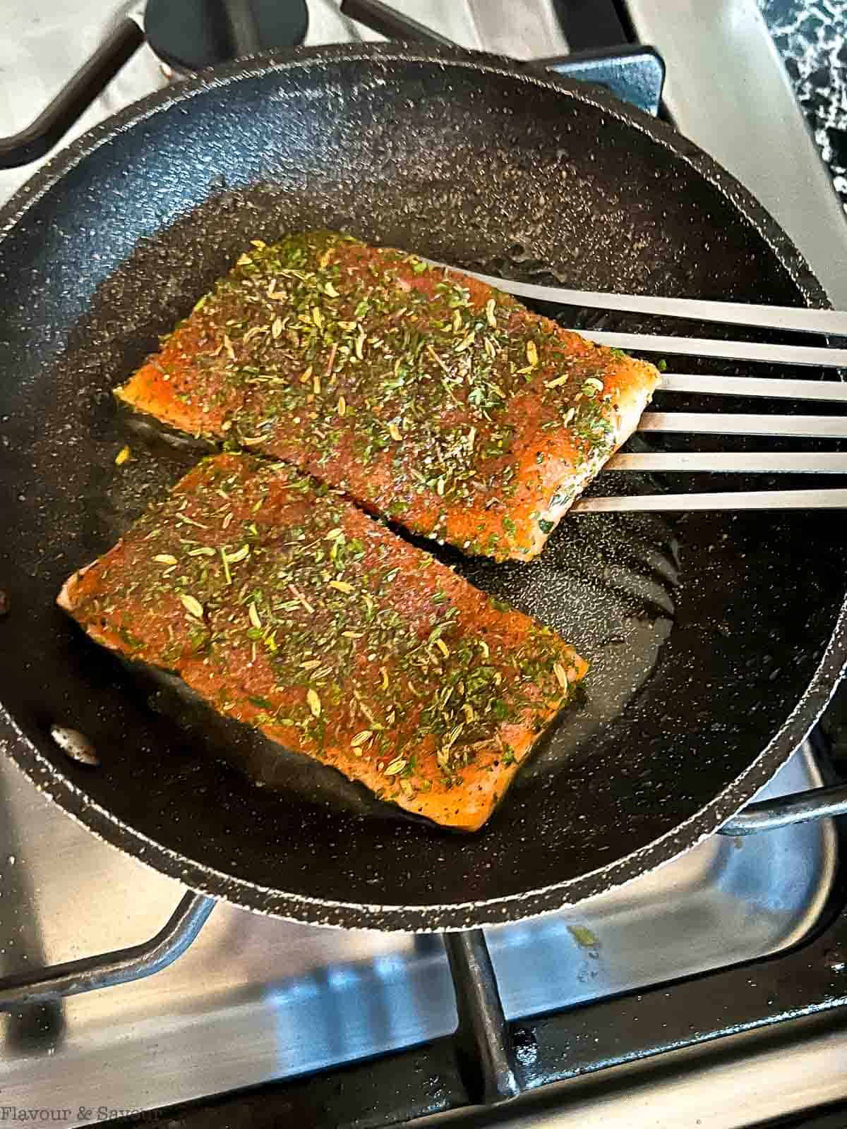 Flipping jerk salmon fillets with a fish turner.