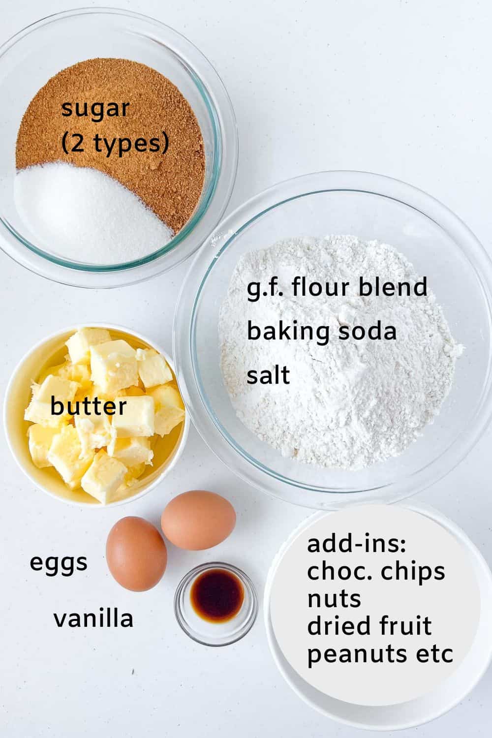 Labelled ingredients for gluten-free Kitchen Sink Cookies. Two types of sugar, gluten-free flour, baking soda, salt, eggs, vanilla, butter and add-ins.