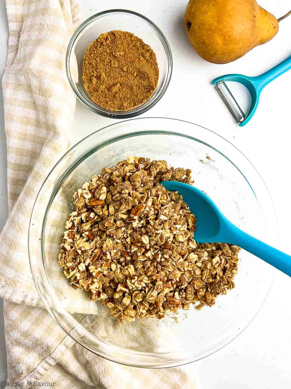 Crumble topping for pear crisp in a glass bowl.