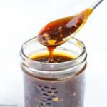 A spoonful of teriyaki sauce in a small Mason jar.